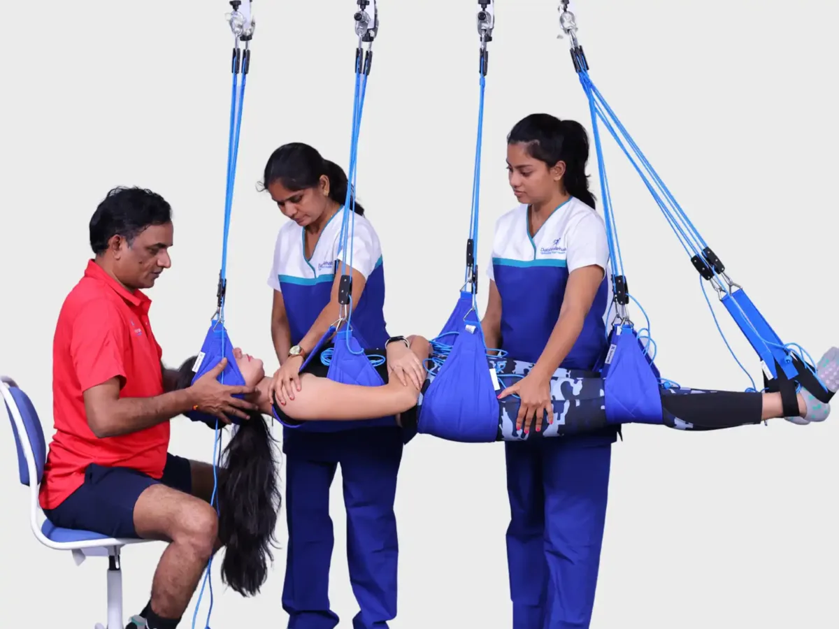 Patient performing Redcord Neurac suspension therapy with a physiotherapist at DakshinRehab