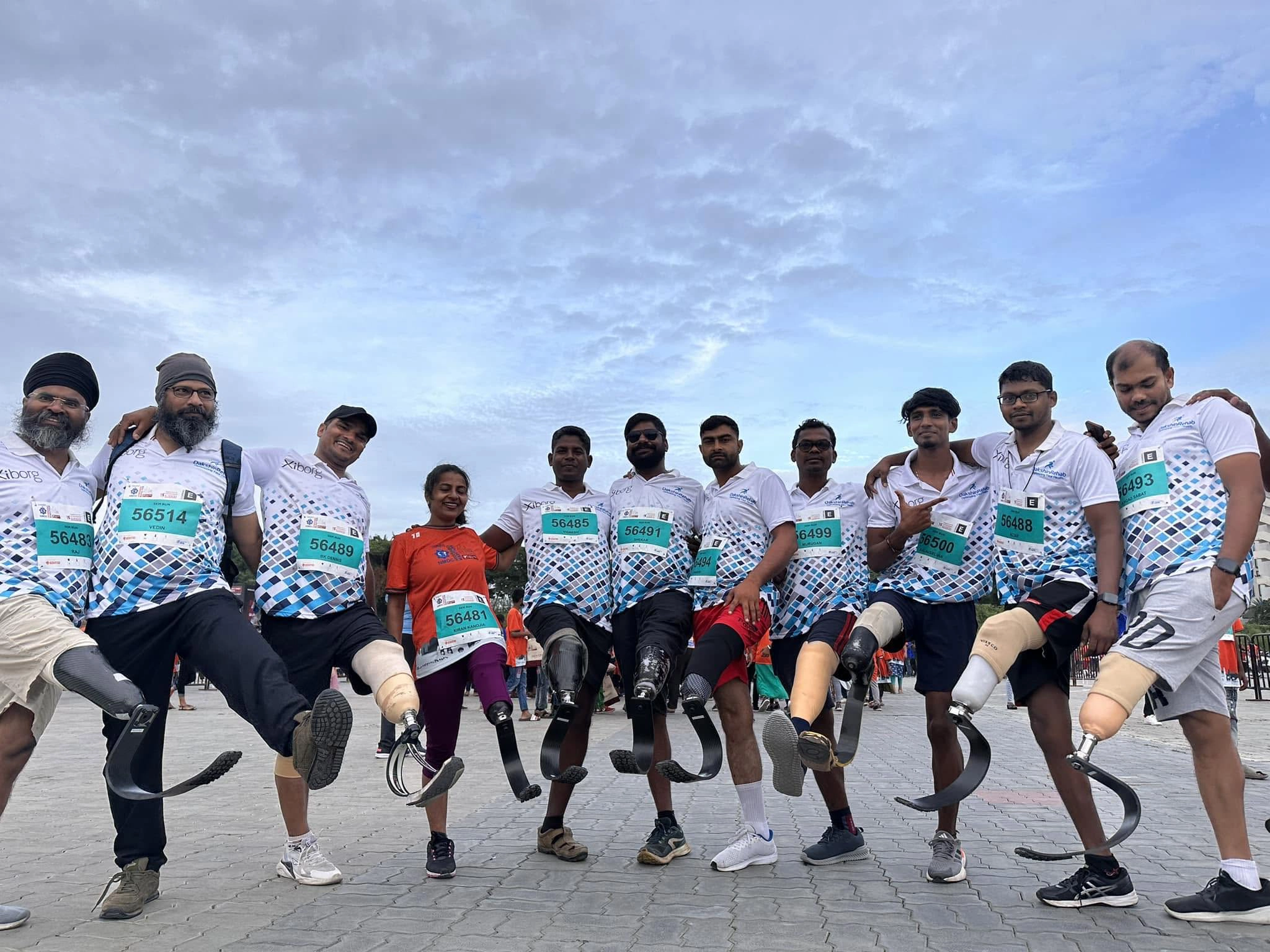 Group of DakshinRehab amputee athletes with running-blade prostheses at a road race