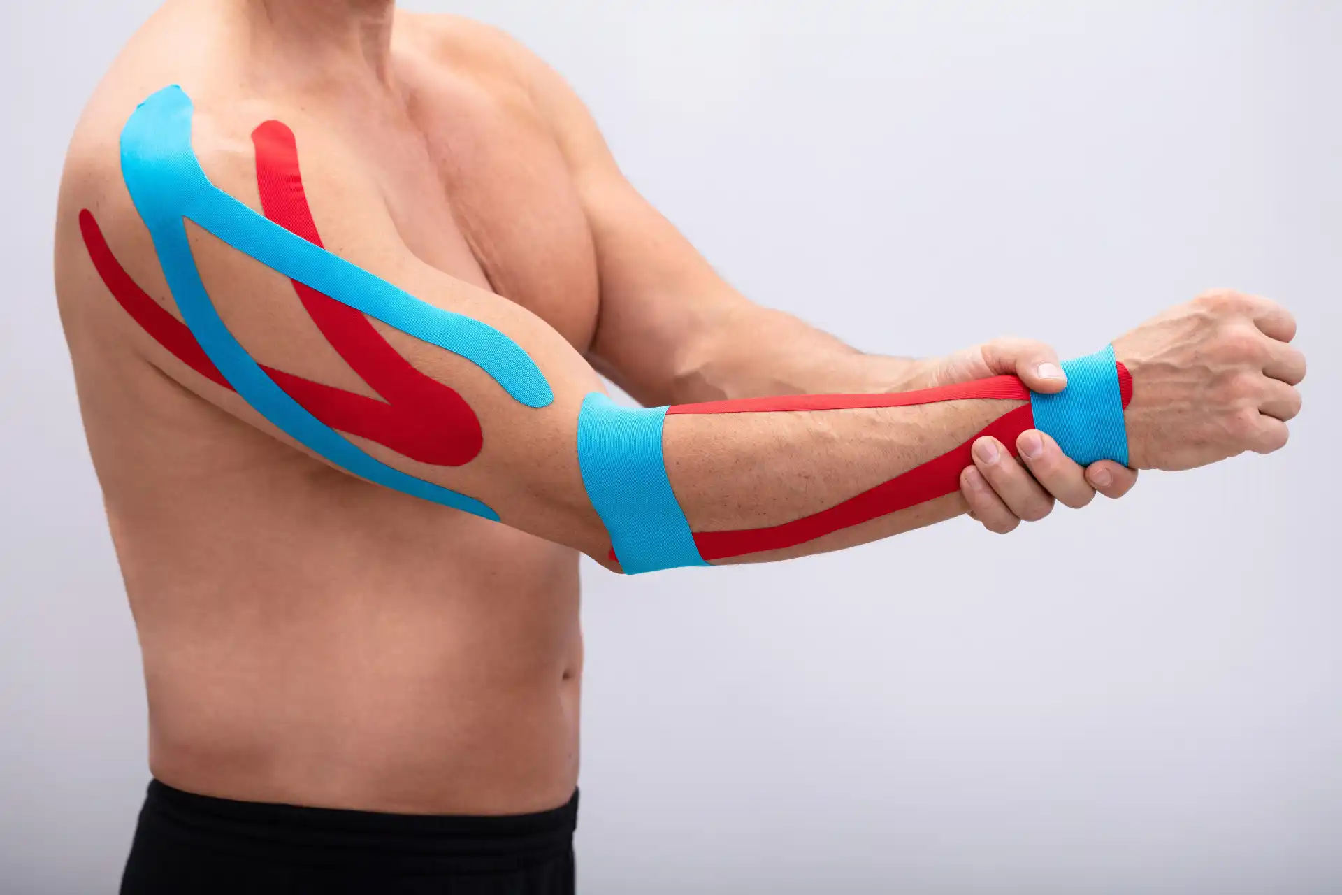 MPT-certified physiotherapist applying kinesio tape during a treatment session at DakshinRehab Moosapet, Hyderabad