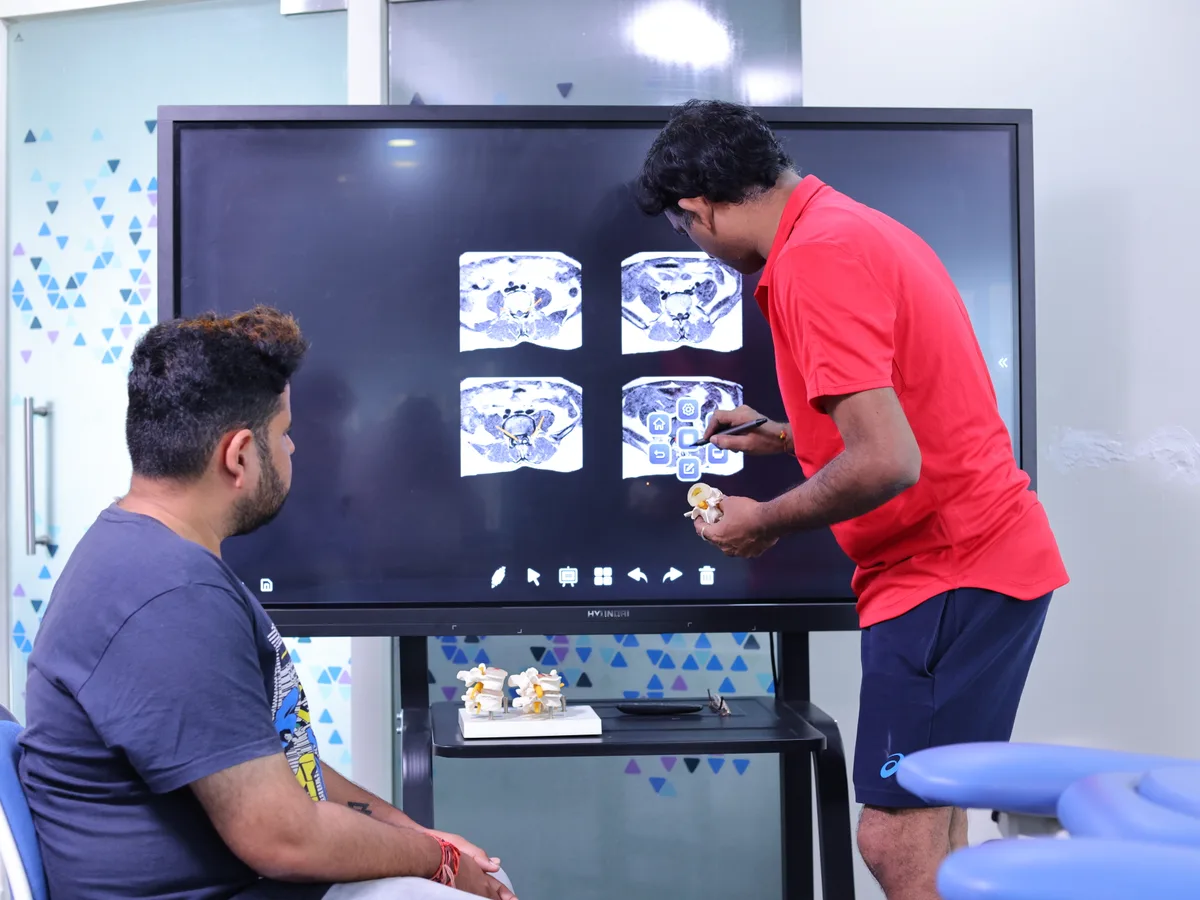 Clinician reviewing spine MRI with a patient at DakshinRehab, Moosapet, Hyderabad