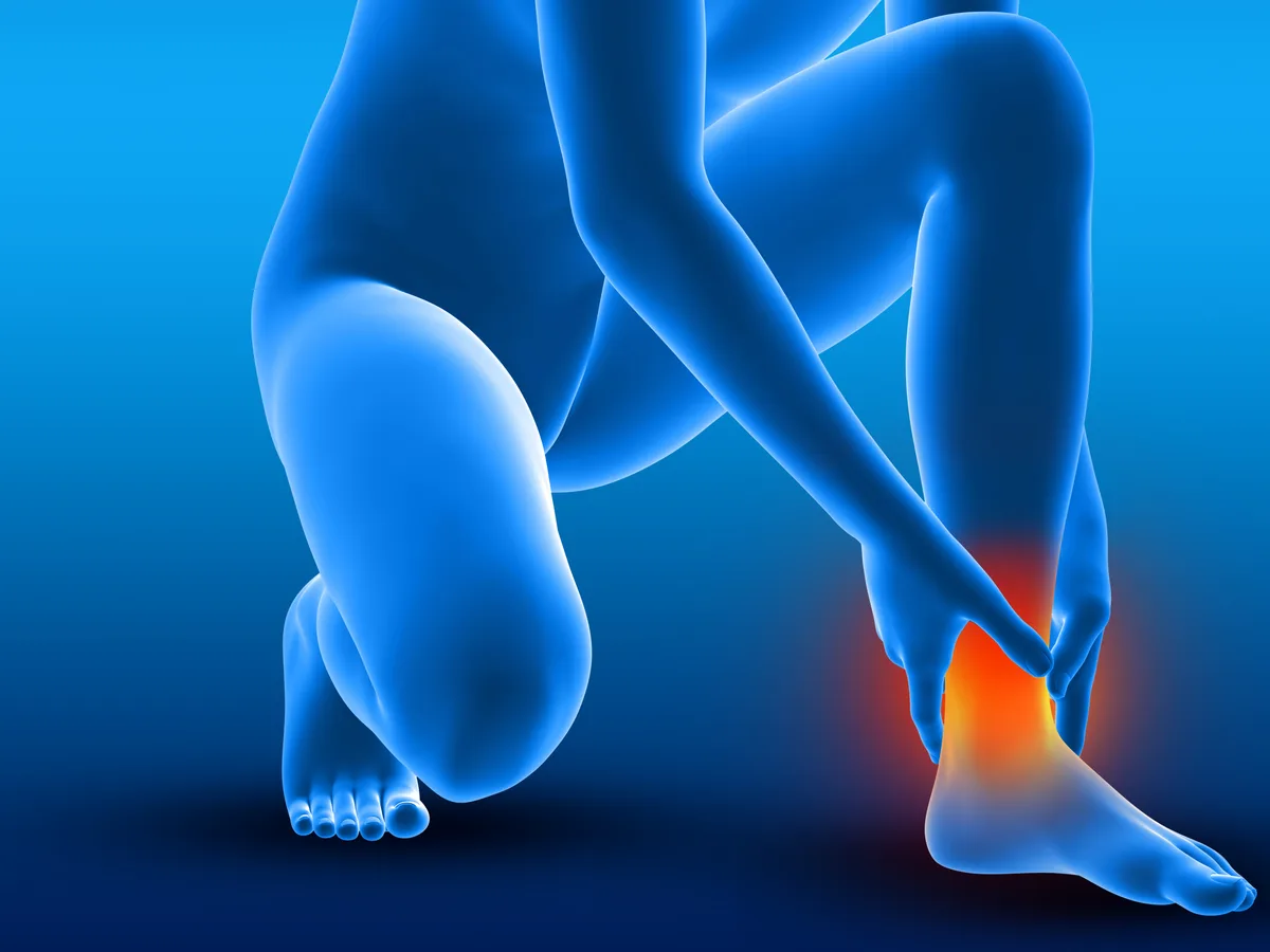 Athlete grabbing a severely swollen ankle after a fall