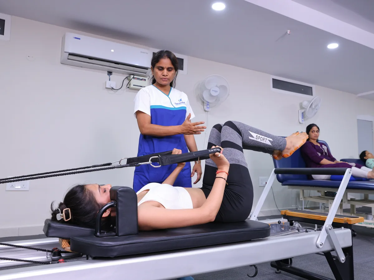 Woman in her 30s performing deep core activation with Levitas Neurac suspension therapy at DakshinRehab Moosapet