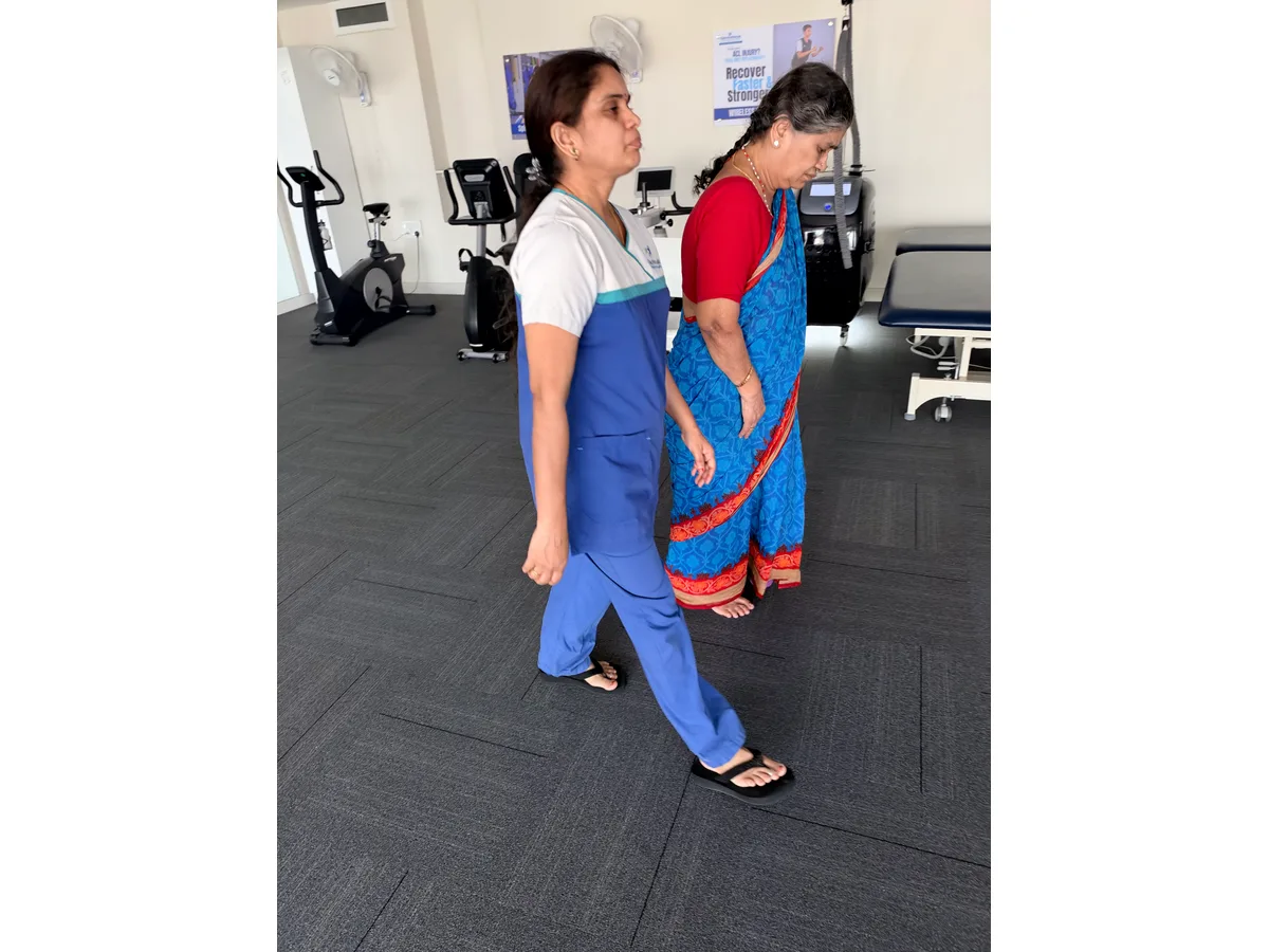 Physiotherapist walking beside a patient at DakshinRehab