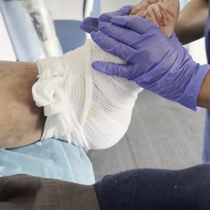 Clinician supporting a dressed foot during movement assessment at DakshinRehab
